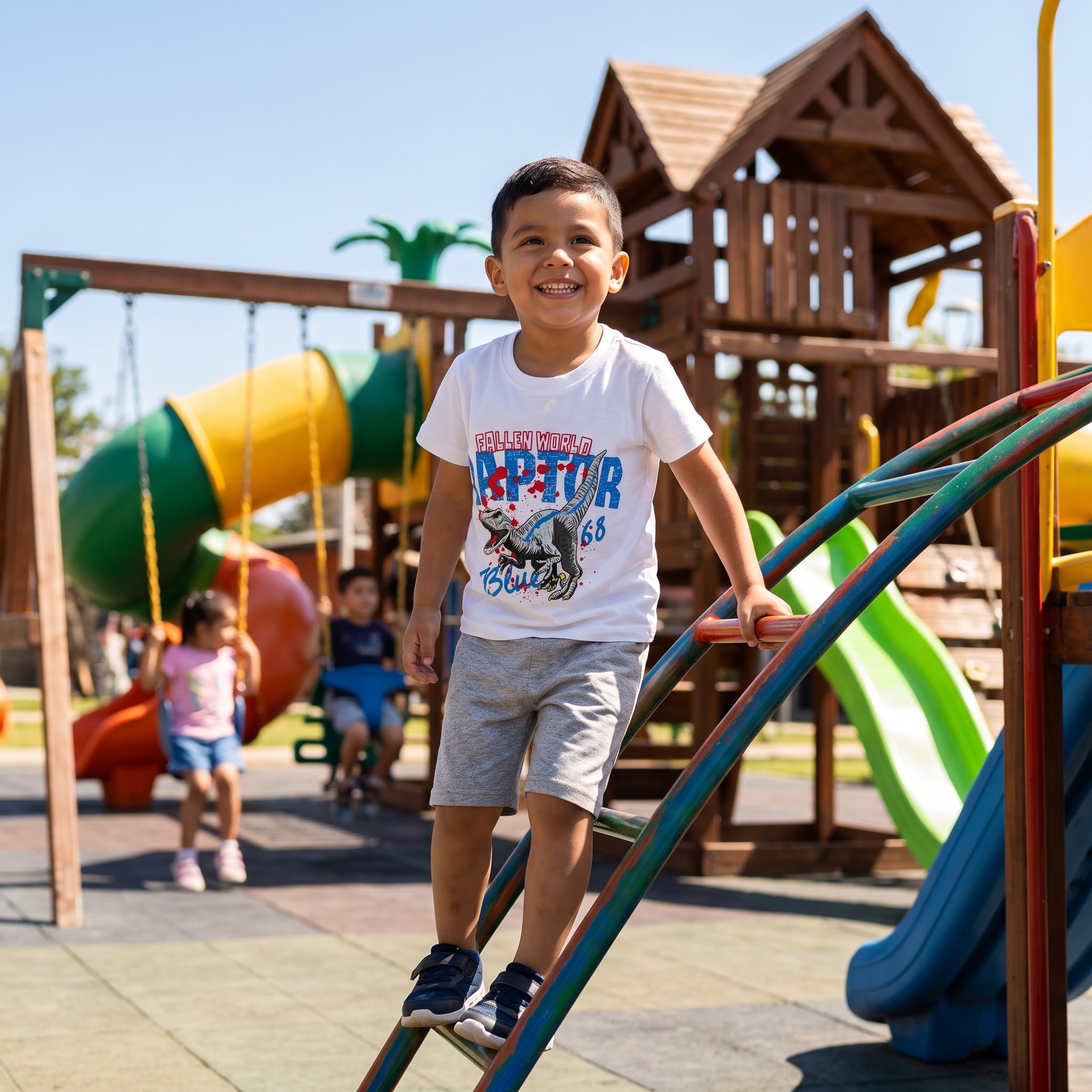 lifestyle: A new photorealistic photograph, not a modification of any input image. The input is provided for product identity reference only. A bright and cheerful park playground on a sunny day, with colorful slides, swings, and climbing frames visible in the background. A joyful Latino/Hispanic boy, approximately 4-5 years old, with short dark hair, wearing the product. He is actively playing, perhaps mid-swing or climbing a ladder, with a big smile, clearly demonstrating the comfort and flexibility of t…